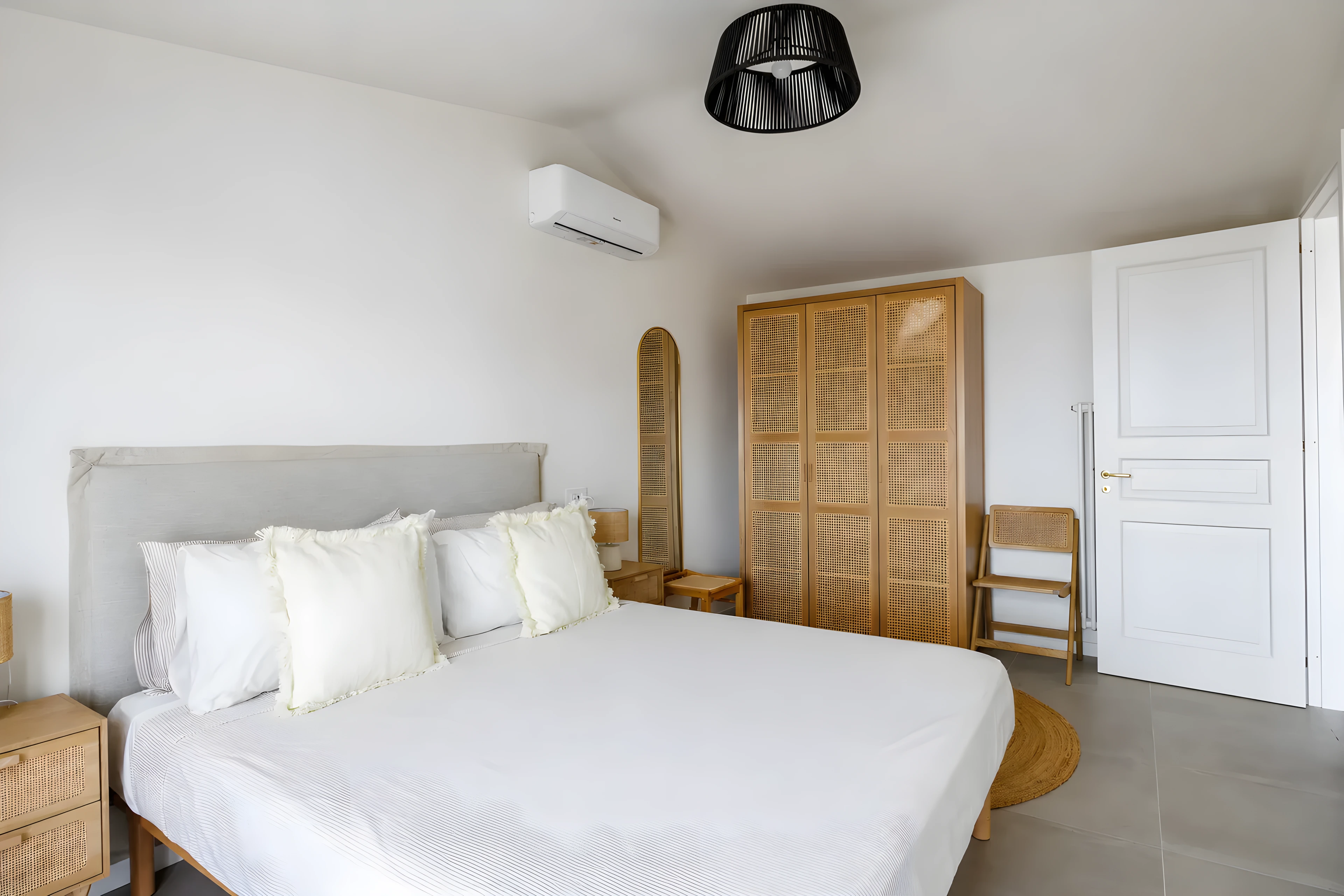 Camera principale con letto matrimoniale, testiera imbottita e armadio in rattan