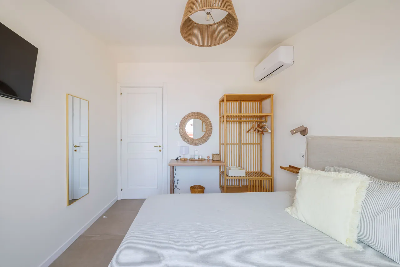 the bedroom with the desk and the cane wardrobe