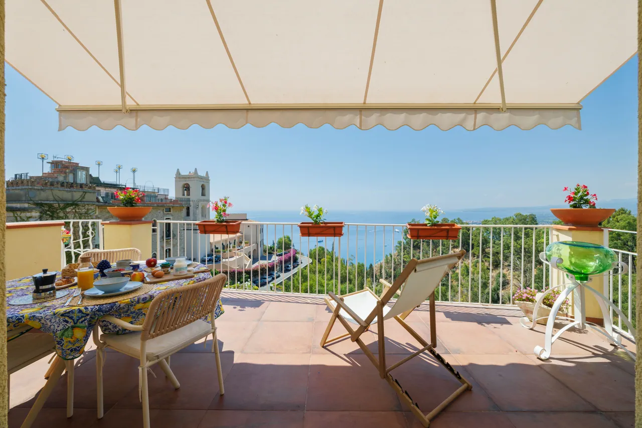 the breakfast terrace, with its awning and the view of the bell tower