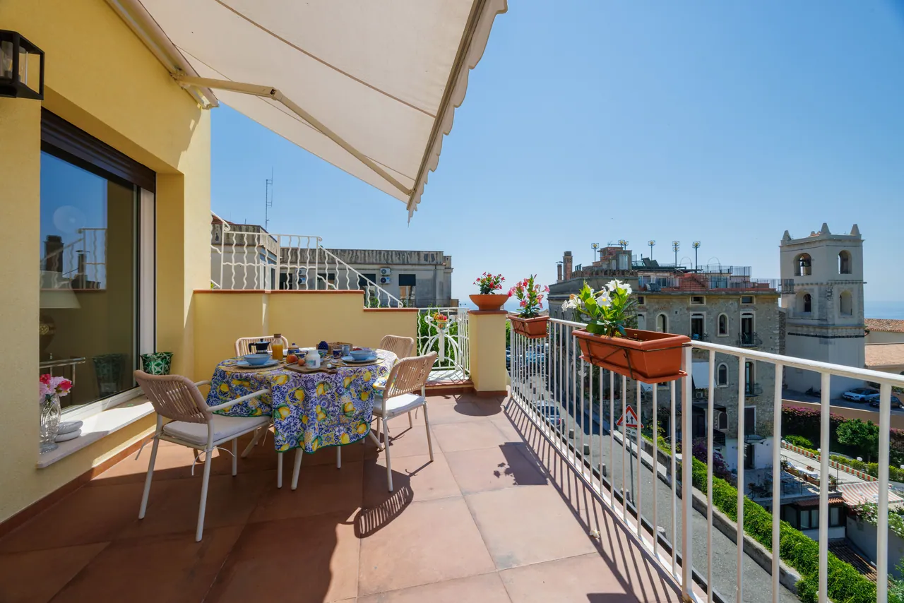 the breakfast terrace, with its awning and the view of the bell tower