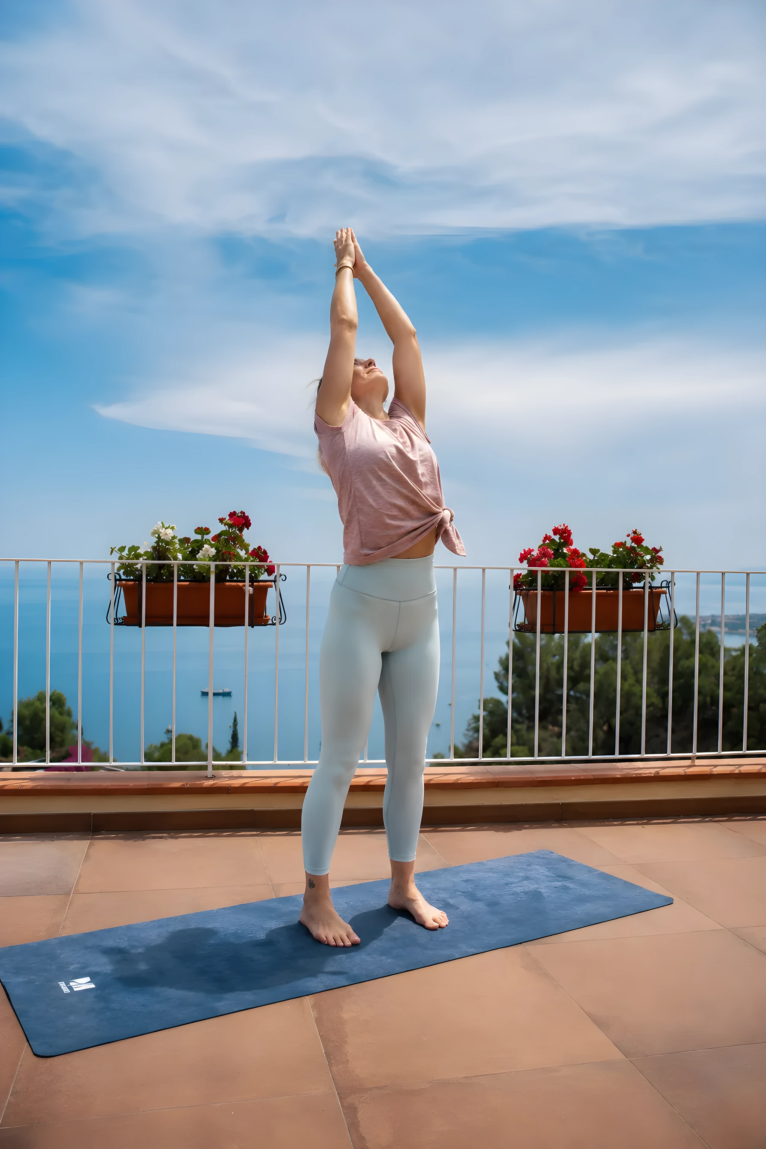Una persona pratica yoga sulla terrazza di Casa Awaya, con il mare sullo sfondo